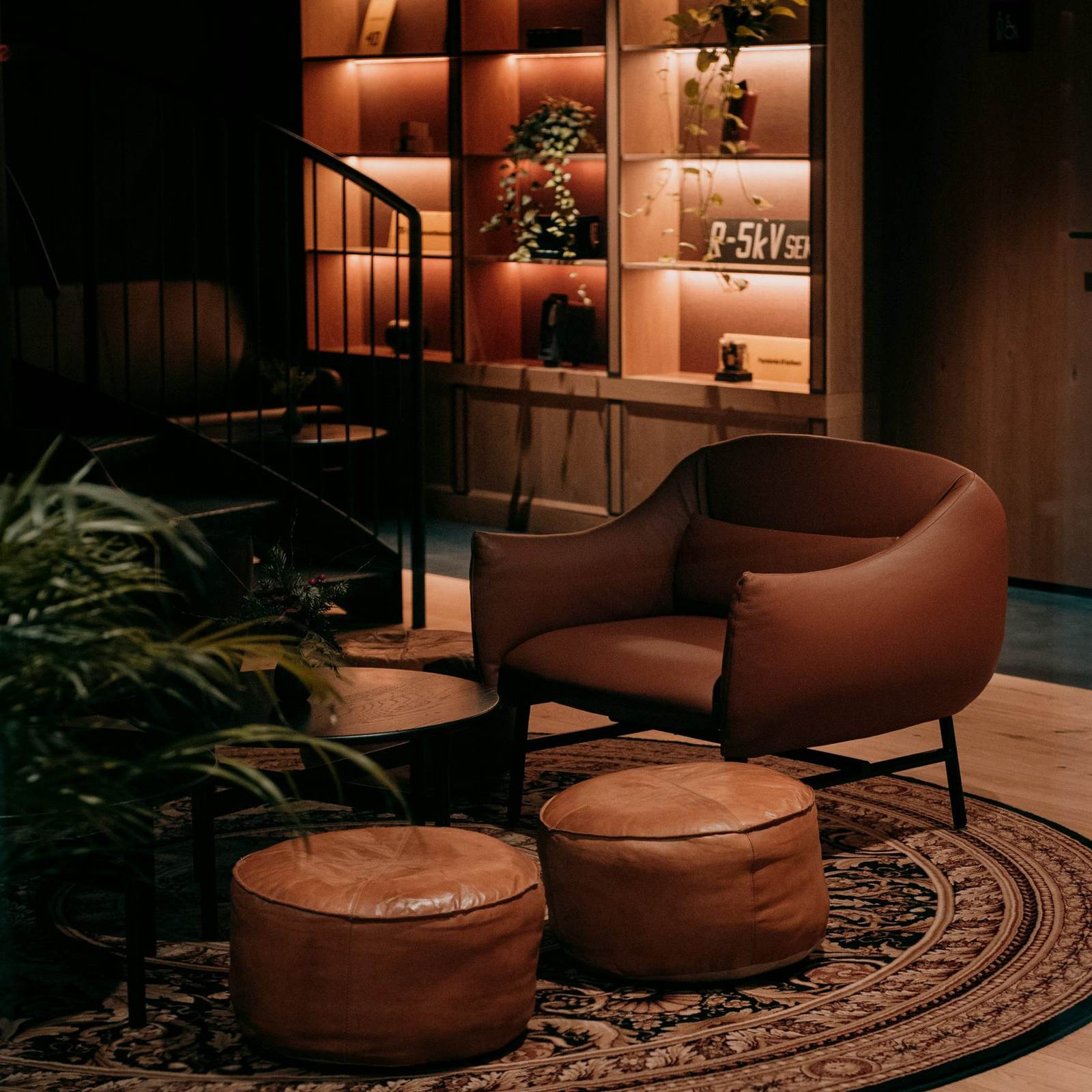 Leather lounge chairs beside a glowing shelf