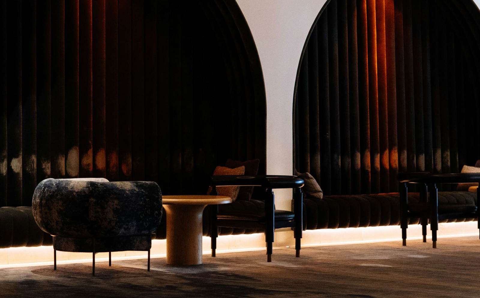 Arched doorways and velvet seating in a moody lounge