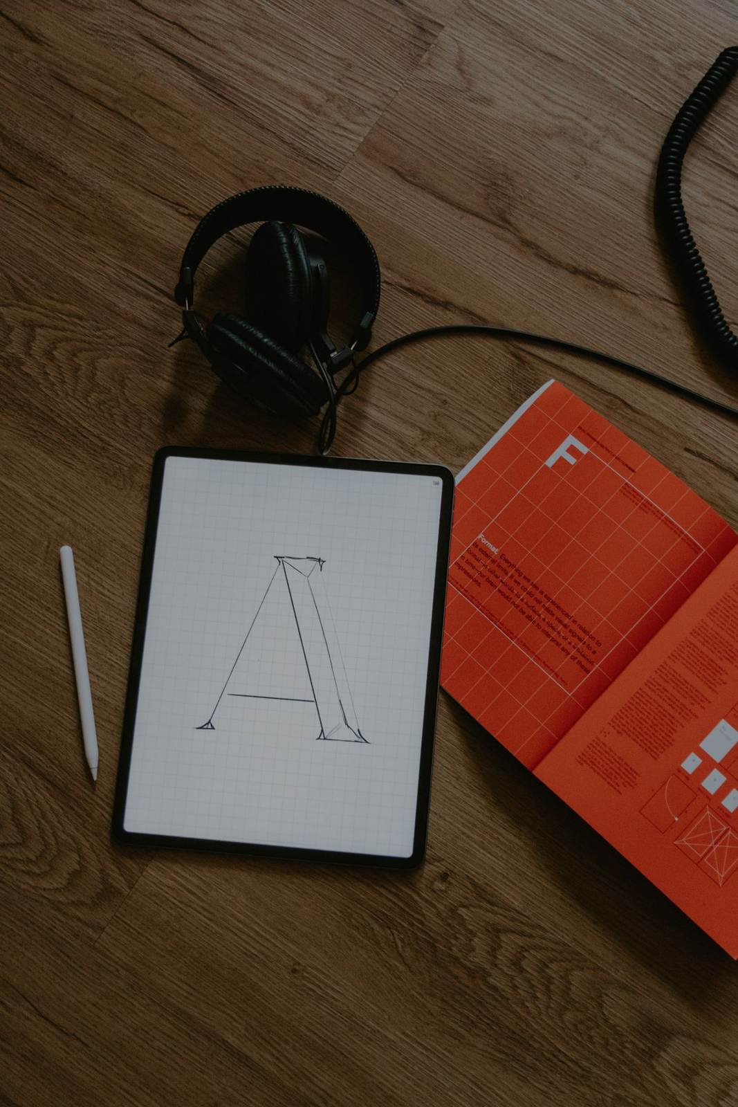 Tablet with a letter A sketch beside print materials