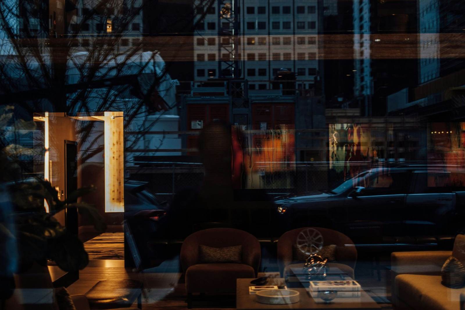 Warmly lit lounge seen through a window at night