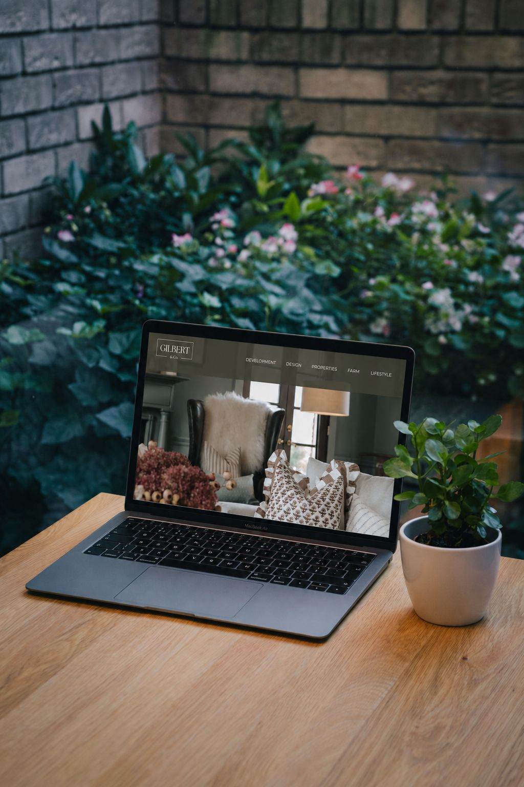 Laptop showing a website on a garden table