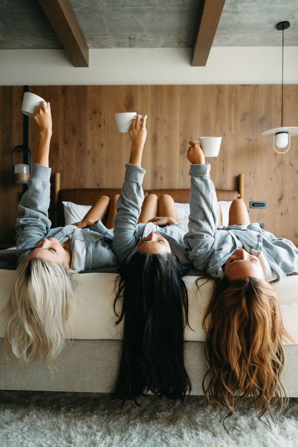 Three guests lying back on a hotel bed